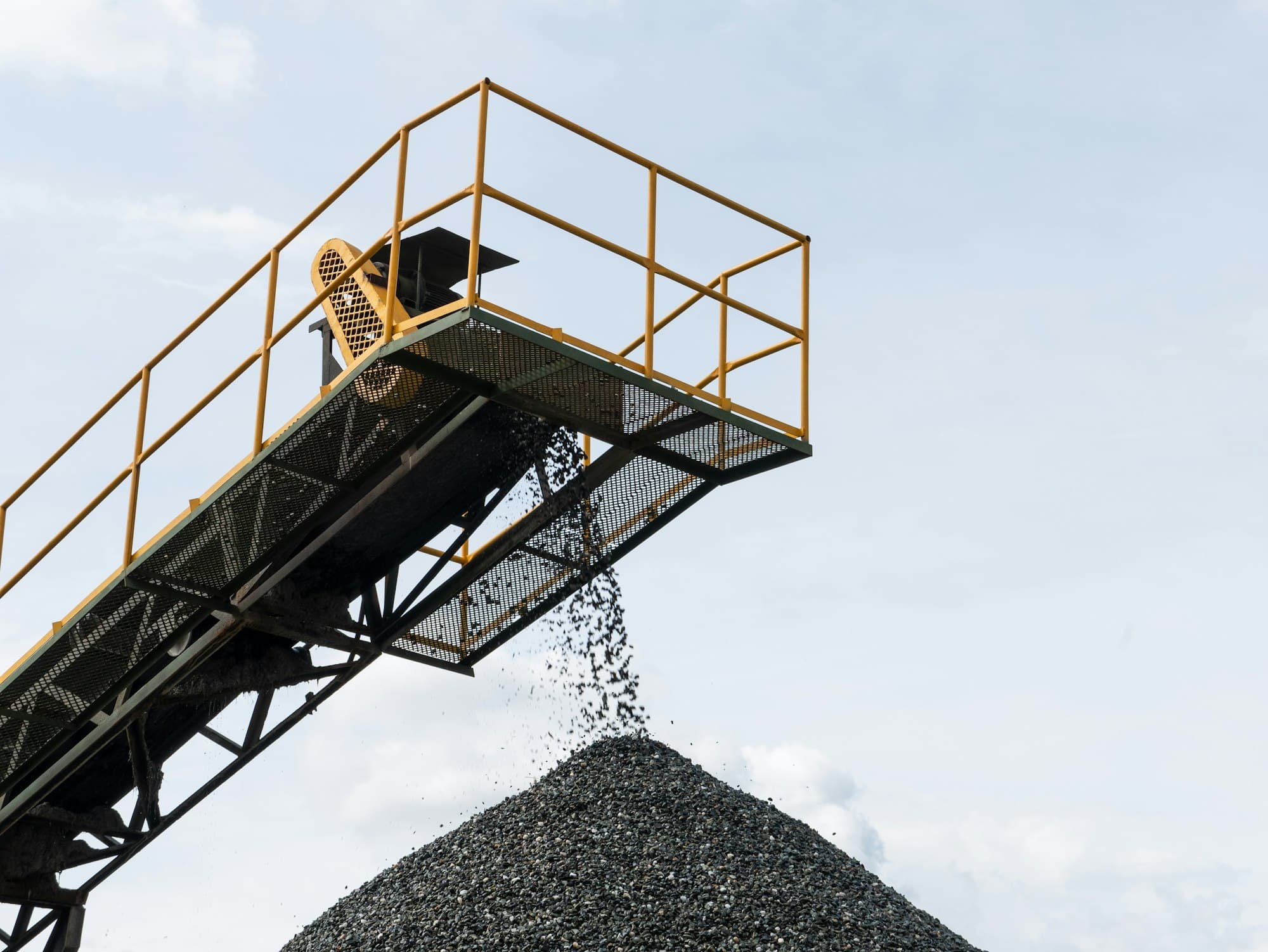 Crushed stone falling from a conveyor onto a stockpile. Not a photograph of an SPR stockpile.